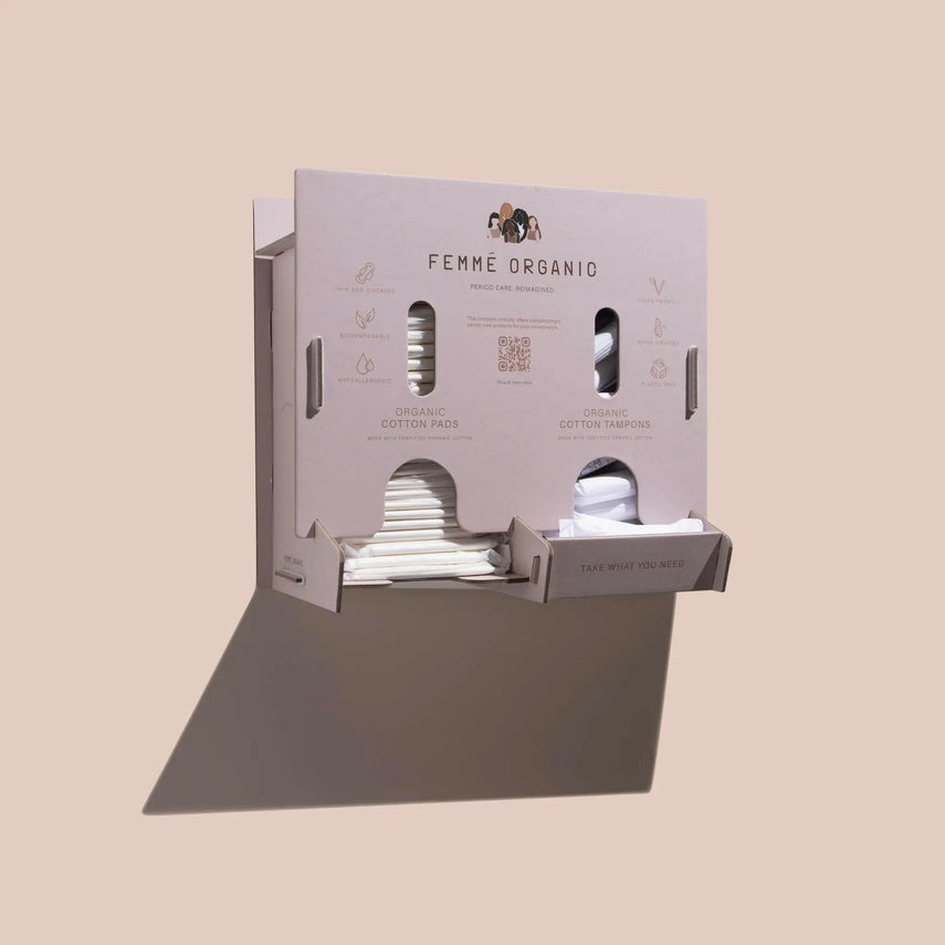 Femme Organic bathroom dispenser with organic period care products, offering plastic-free tampons and pads for sustainable and accessible menstrual hygiene.